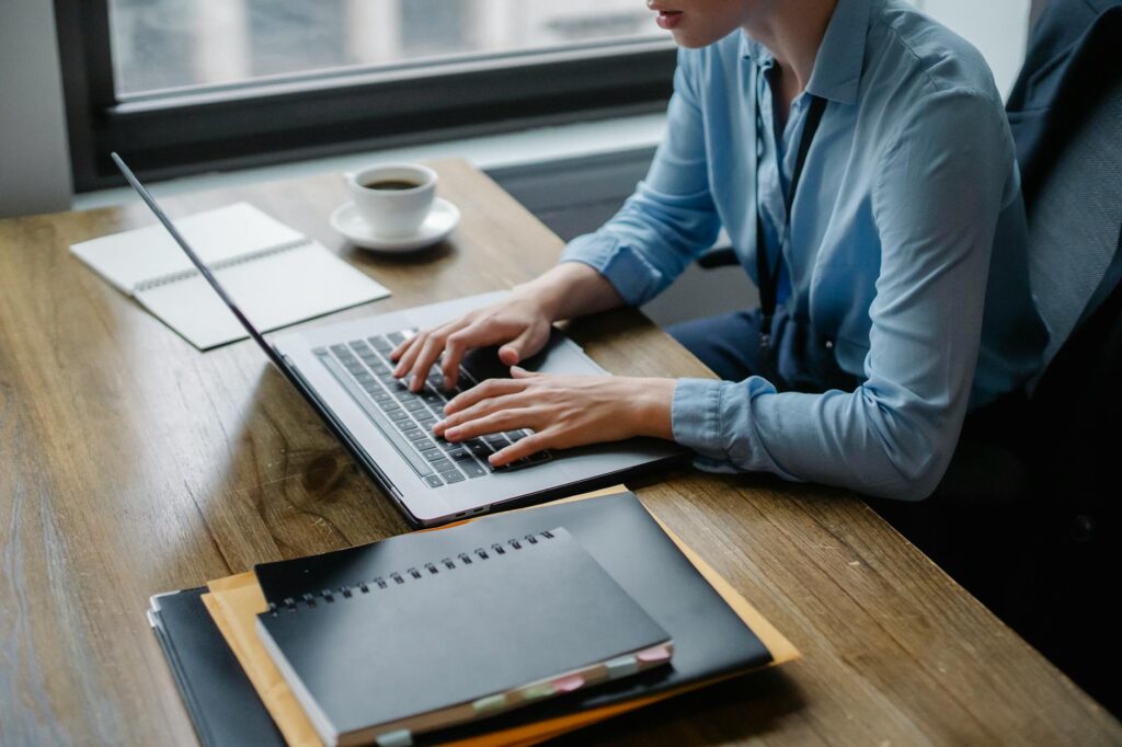 A person reviewing benefits notes at a laptop with a calculator nearby