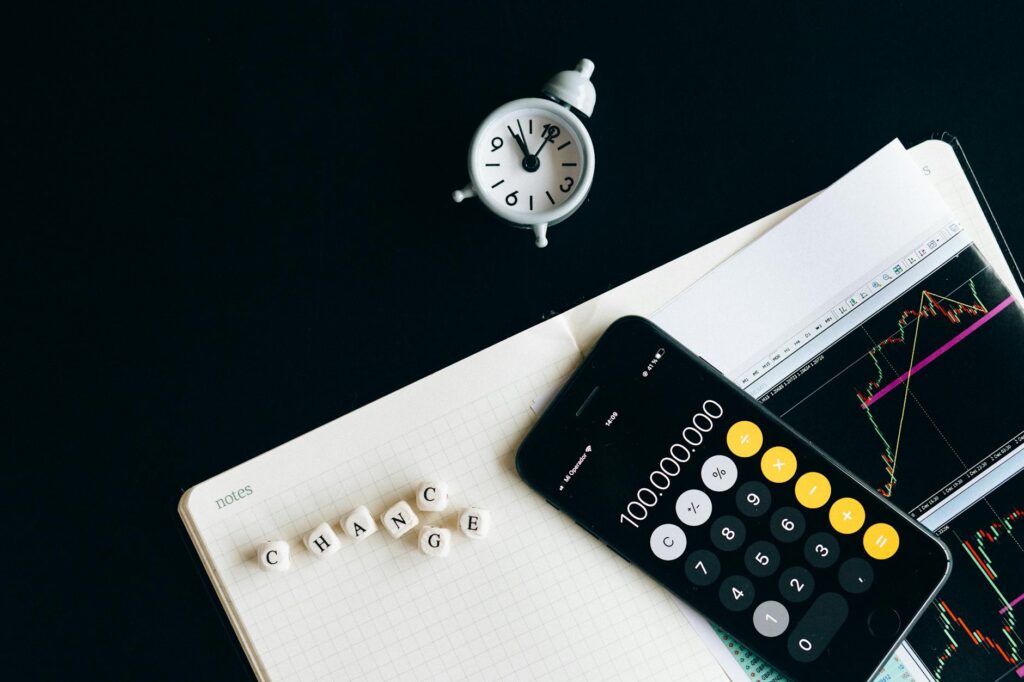 A desk with printed portfolio holdings, a calculator, and handwritten notes for an ETF review.