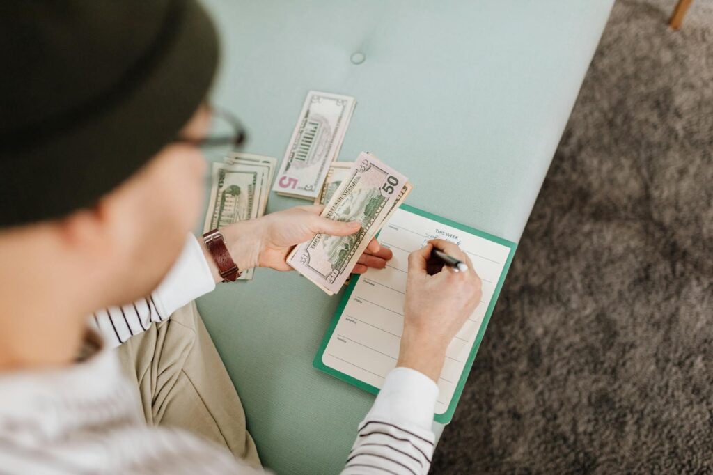 A person reviewing investment notes and household finances at a kitchen table