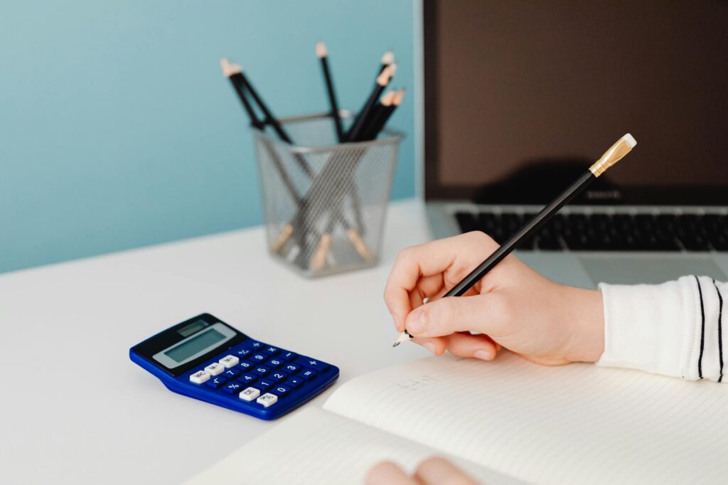 A desk with a brokerage statement, notebook, and calculator used for a portfolio cash audit