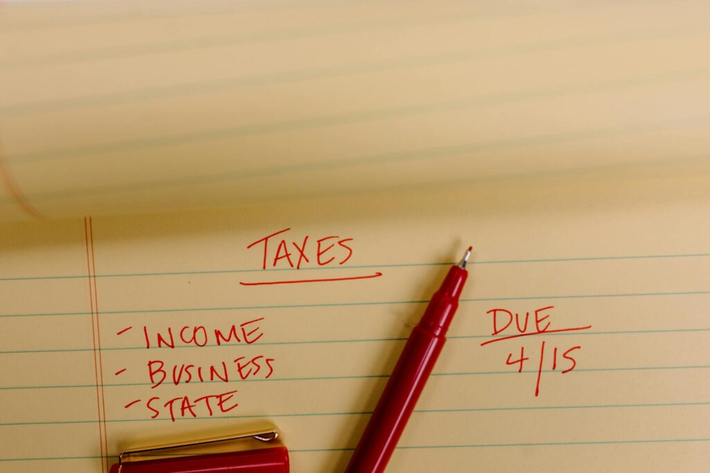 A calculator and investment statements on a desk with handwritten yield calculations.