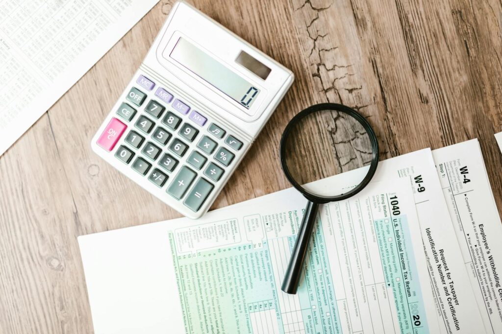 A W-2, paystub, and calculator laid out neatly on a desk