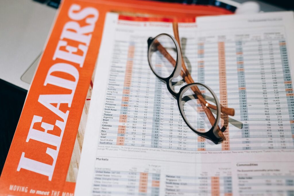 Printed fund documents, reading glasses, and a highlighter on a table