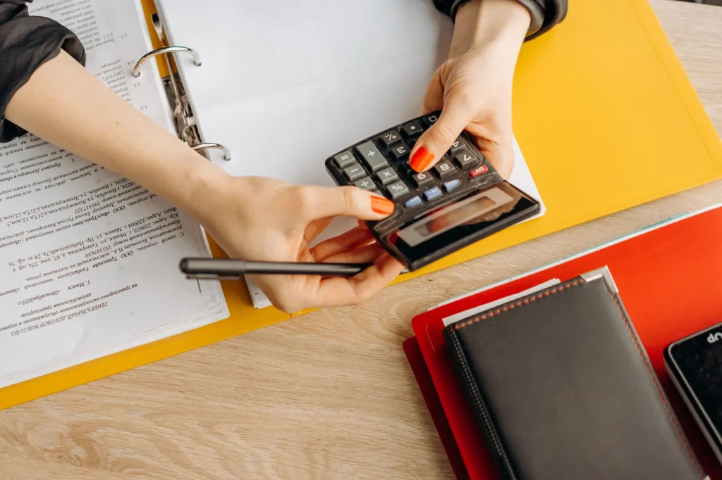 A printed checklist, calculator, and retirement account paperwork on a tidy desk