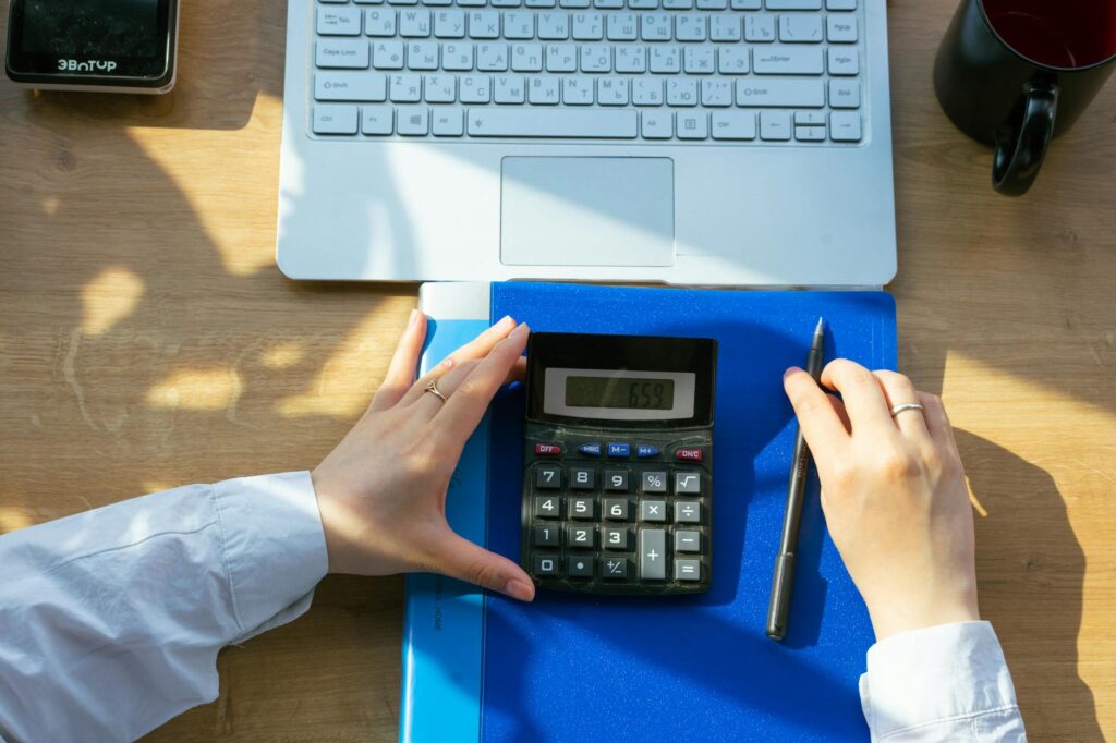 A person reviewing a retirement account statement with a calculator and notebook on a desk