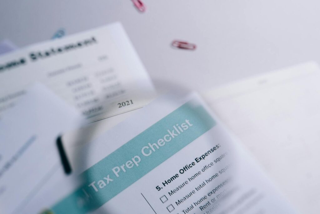 A handwritten financial checklist next to statements and a calculator.