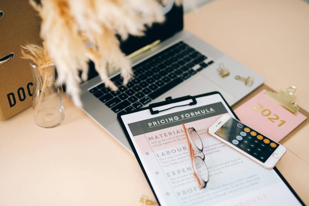 A laptop, calculator, and notebook arranged on a desk for financial planning