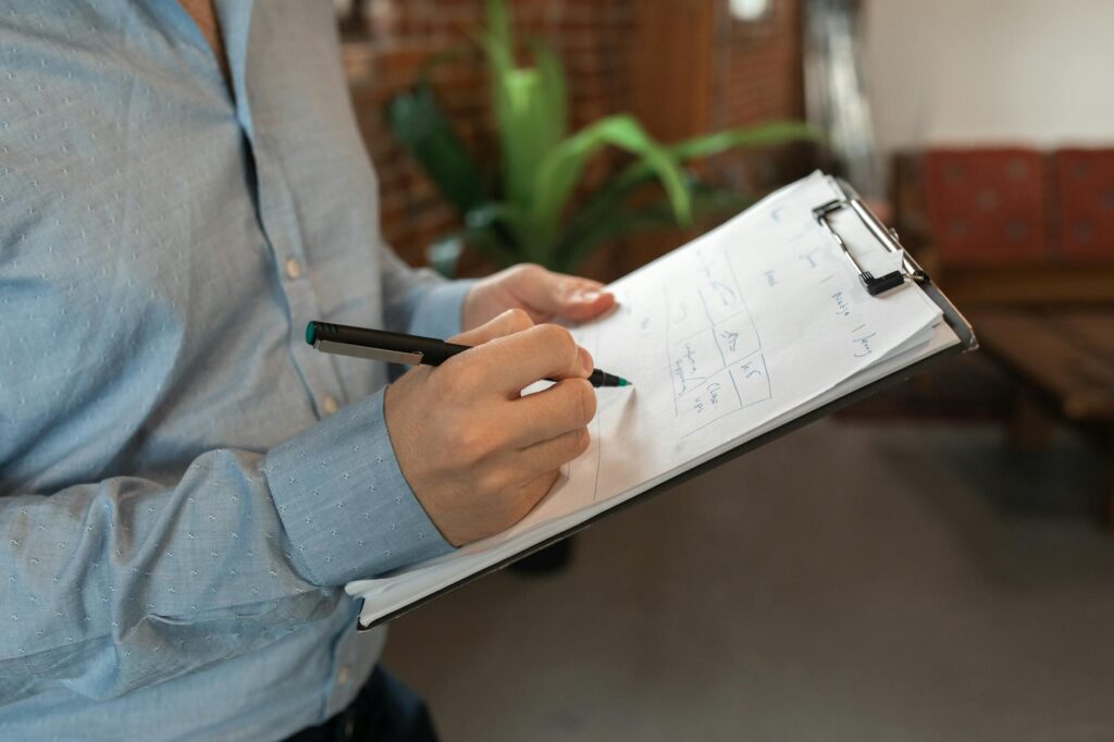 Printed fee schedule and checklist on a desk beside a pen