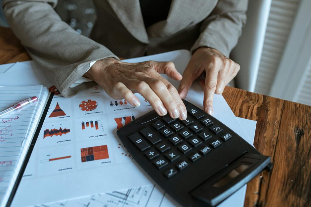 A desk with a calculator, retirement notes, and investment statements