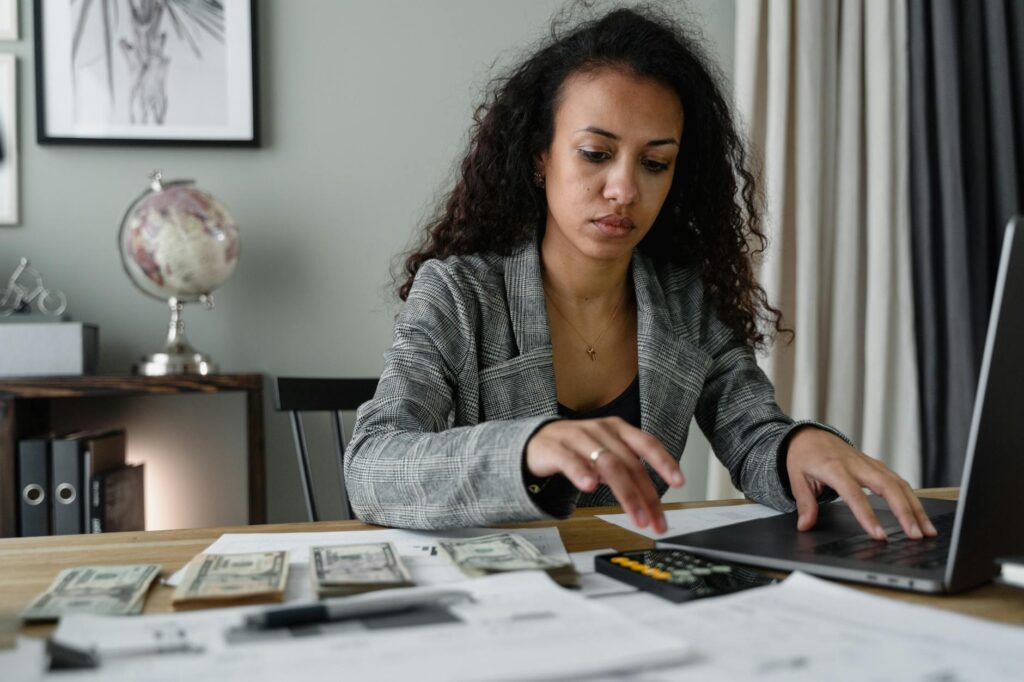 Home-office desk with a laptop, paper statements, and a calculator