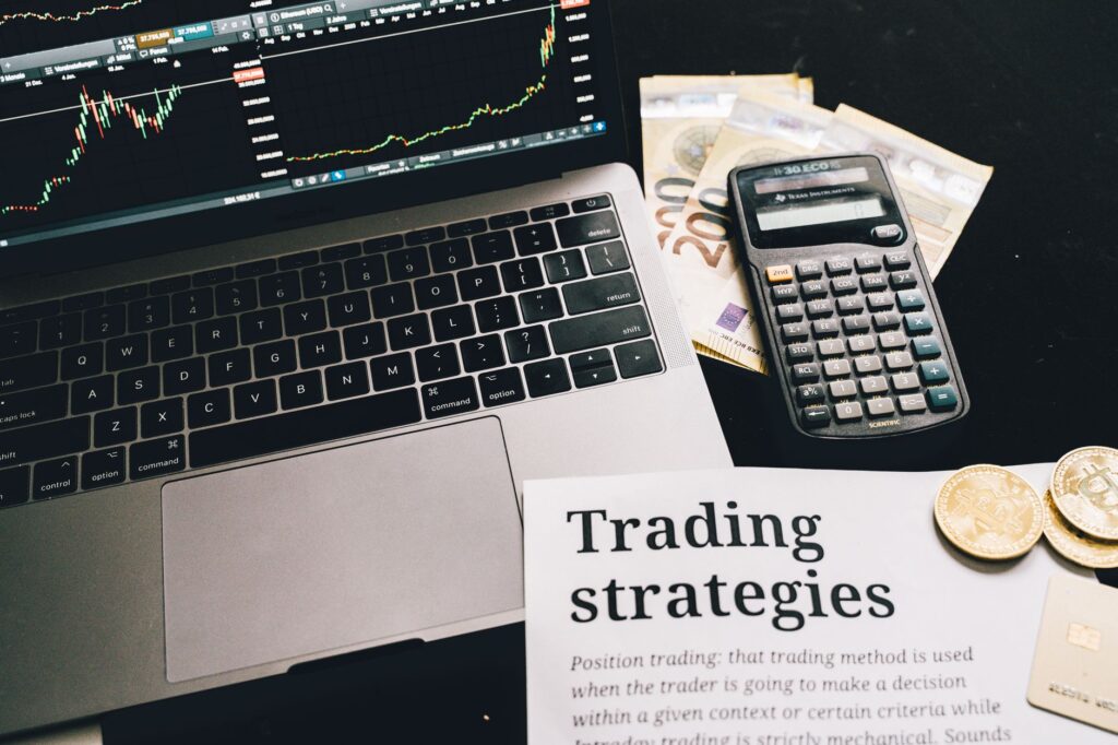 Notebook with asset allocation notes beside a calculator and printed investment paperwork.