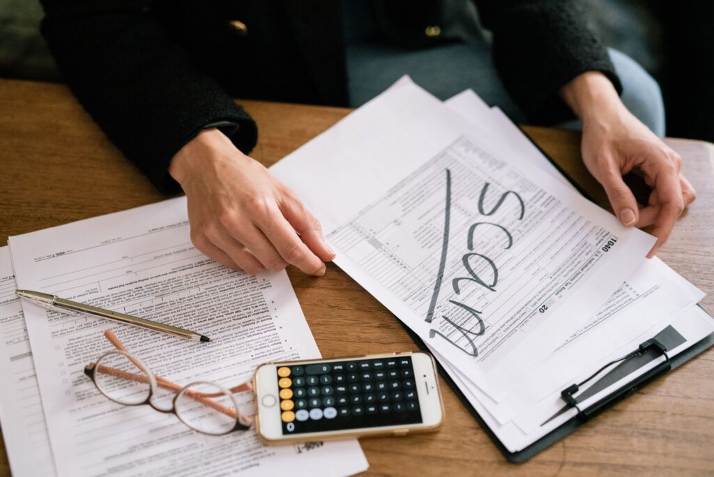 A neatly organized desk with a calculator, printed investment statements, and tax documents.