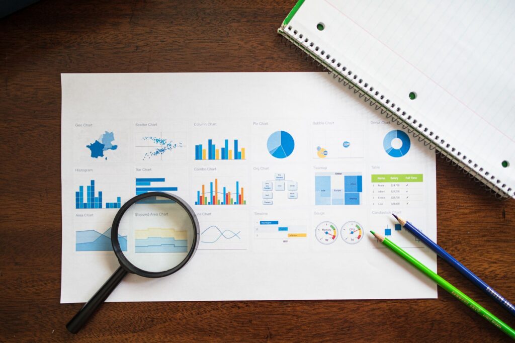 Printed investment statements, a calculator, and a notebook on a home desk
