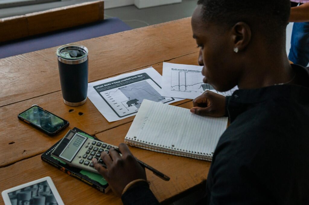 Printed investment documents, calculator, and notes on a clean desk